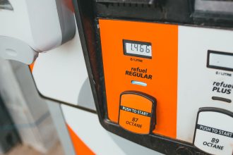 Detalhe de uma bomba de combustível com visor indicando preço e octanagem.