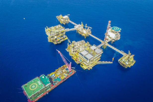 Vista aérea de um complexo de plataformas petrolíferas offshore em alto-mar.