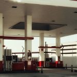 Posto de combustíveis moderno, com várias bombas de abastecimento sob uma cobertura iluminada.